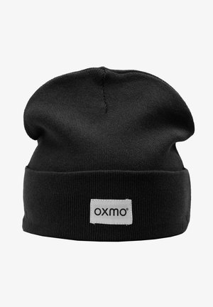 Černá pletená čepice vyrobená z měkké látky, s ohrnutým lemem. Na přední straně je našitý obdélníkový štítek s názvem značky "oxmo".