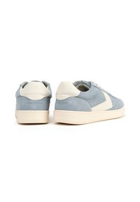 Sneakers blu scamosciati con accenti in pelle bianca, suola piatta beige, punta rotonda e logo del marchio visibile sul tallone.