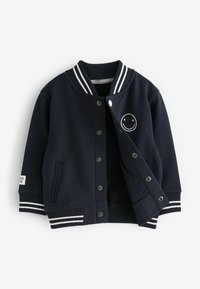 Donkerblauw varsityjack met witte gestreepte ribbelkraag en manchetten, drukknoopsluiting, vo pocket en geborduurde glimlachend gezichtdetail.