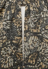 Black and beige fabric featuring a butterfly pattern with fine details; includes pleats and a vertical opening design.