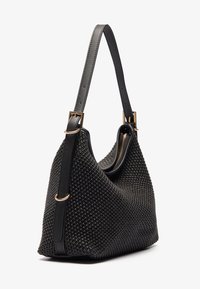 Černá tkaná kabelka s texturovaným povrchem, koženými doplňky, nastavitelným popruhem a zlatým kováním, vybavená zipem na horním otvoru.