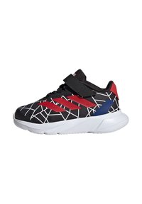 Chaussure de sport noire avec des accents rouges et bleus ; présente un motif en toile, une sangle Velcro et une semelle blanche texturée.
