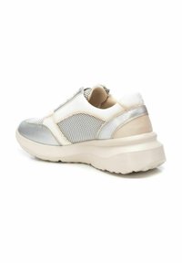 Zapatilla plateada y blanca con parte superior de malla, acentos de cuero suave, cuello acolchado y suela gruesa. Presenta un diseño texturizado.