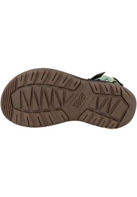 Brown rubber outsole with a textured, patterned surface. Features a raised logo and grooves for traction. Designed for outdoor use.