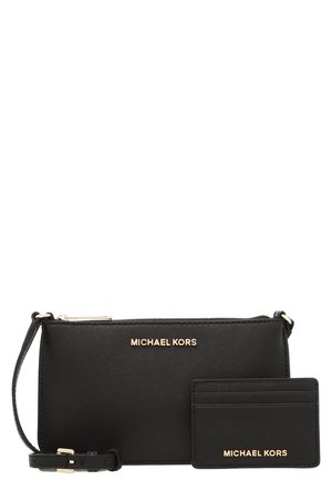 Czarna torebka na nadgarstek Michael Kors z dopasowanym portfelem na karty, oba z złotym logo i zamkiem błyskawicznym na torebce.