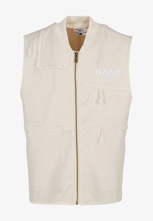 Beige mouwloze vest met ritssluiting, voorzien van rafelige accenten, twee voorzakken en geborduurde tekst op de borst.