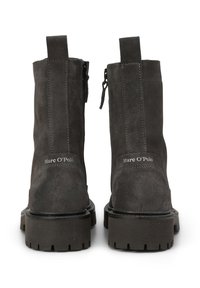 Paar dunkelgraue Wildleder-Stiefel mit klobigen Sohlen, Reißverschluss hinten, Laschen zum Anziehen und "Marc O’Polo"-Branding am Fersenbereich.