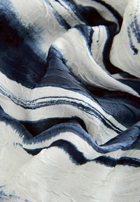 Silk fabric with flowing texture, featuring blue and white stripes in varying widths, creating a soft, layered appearance.