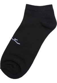 Svart ankelsocka gjord av ett mjukt tyg. Har en ribbad kant och en liten vit logga på sidan. Rundad tådesign och slät textur.