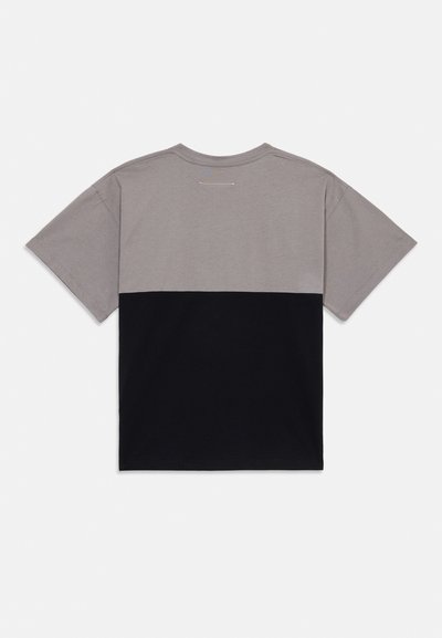 Grå och svart färgblockerad kortärmad t-shirt med rund halsringning och en mjuk bomullstextur. Minimal sömdetalj på baksidan.