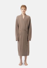 Bälte badrock i mjuk taupe-fabric, knälång, med långa ärmar och två framfickor, med en omslagsdesign och minimal textur.