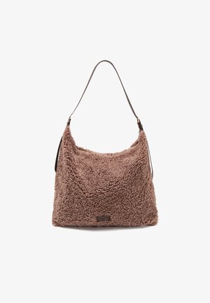 Bolso de hombro marrón de textura suave con una amplia correa única y una etiqueta sutil de la marca en la parte frontal, colocado sobre un fondo blanco.
