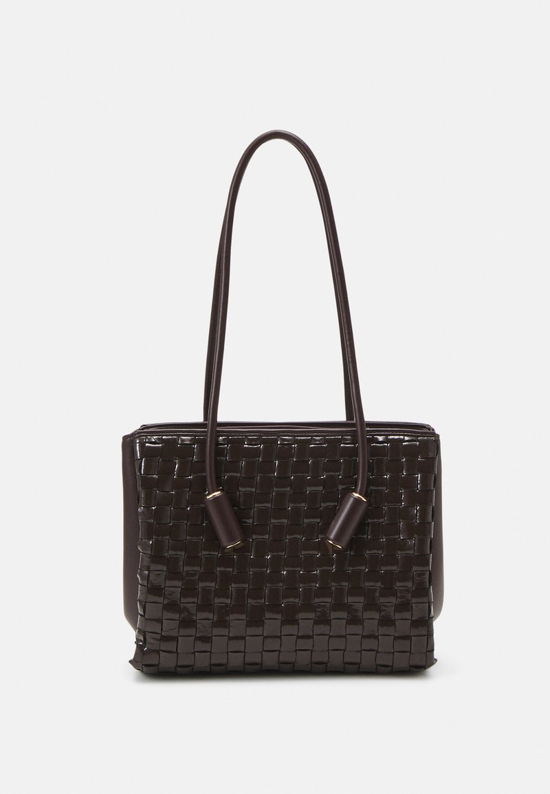 Bolsa de mão tecida em tons de castanho com acabamento brilhante, forma retangular, duas alças longas e detalhes em dourado. Superfície texturizada com padrão de cesta.