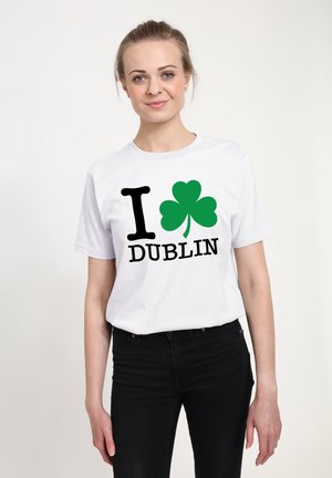 T-shirt bianco con il testo "I ♥ Dublin" in nero e un design di trifoglio verde, realizzata in cotone con maniche corte e scollo rotondo.