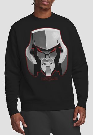 Schwarzer Sweatshirt mit einem Grafikdesign eines Roboterkopfes in Grautönen und Rot, mit dem Text "TRANSFORMERS" unter dem Design.