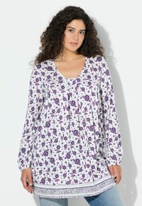 Blusa bianca a maniche lunghe con motivo floreale viola, scollo a giro, pieghe e bordo decorato all'orlo. Cotone o materiale leggero simile.