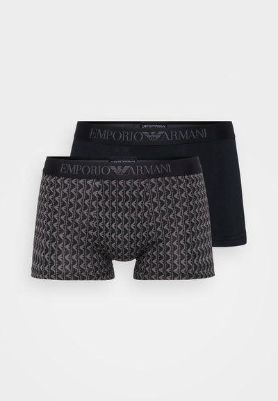 Two pairs of men’s boxer shorts: one with a geometric pattern in gray and black, the other solid black, both with branded elastic waistbands.