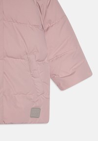 Kerge roosa, volüümikas jope pehme tekstuuriga, külgpocketi ja ruudukujulise halli logoga; loodud soojuse ja mugavuse tagamiseks.