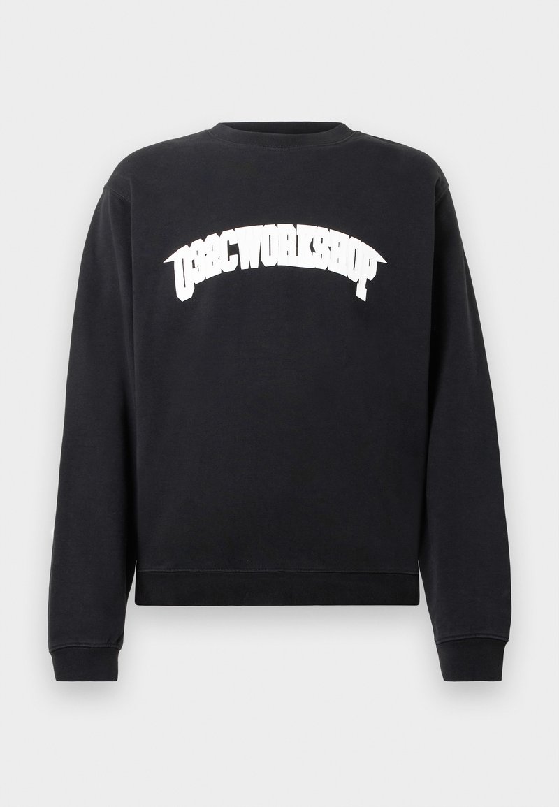 Zwarte sweatshirt met lange mouwen en witte vetgedrukte tekst "OBSC WORKSHOP" in een gebogen lijn over de borst, met een ronde hals en geribbelde manchetten en zoom.