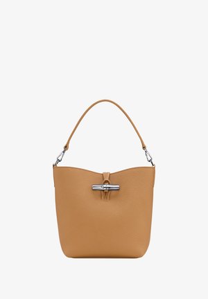 Tan leather handbag with a textured surface, featuring a curved top, a central clasp closure, and a single shoulder strap.