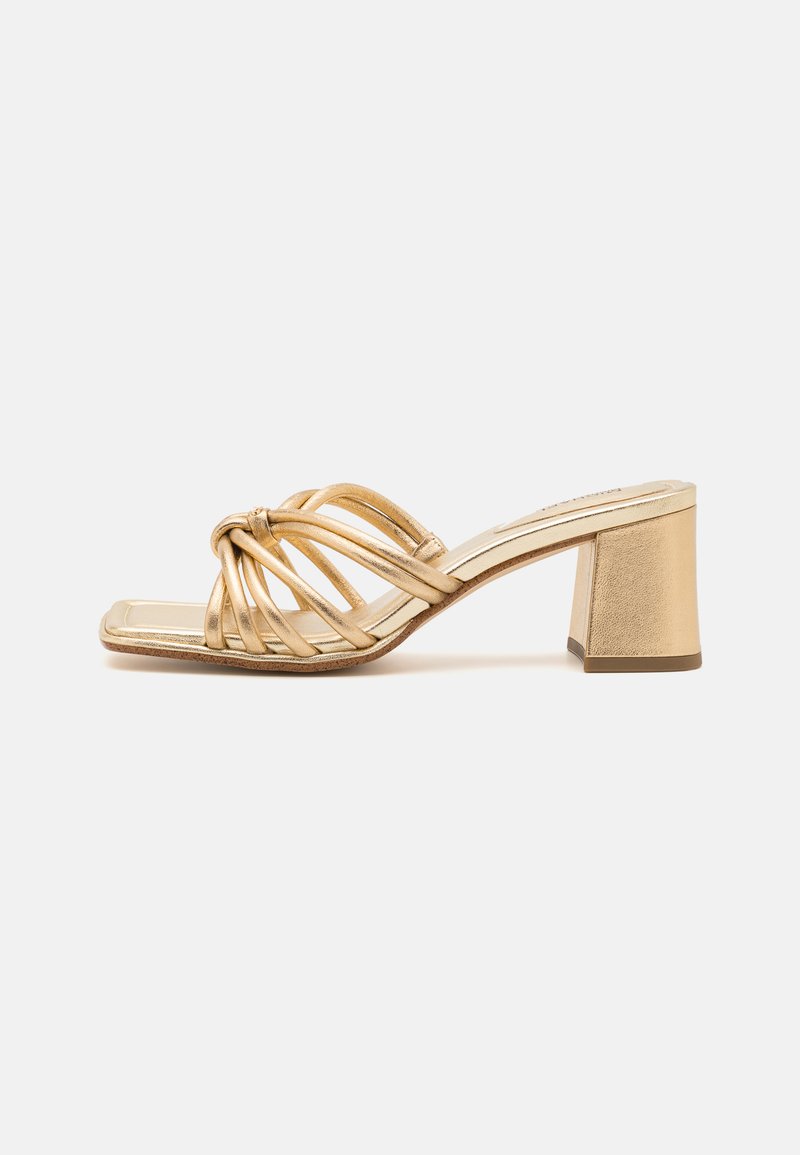 Goldene Sandale mit Blockabsatz, die mehrere verwobene Riemen aufweist. Sanfte metallische Textur und quadratisches Zehendesign.
