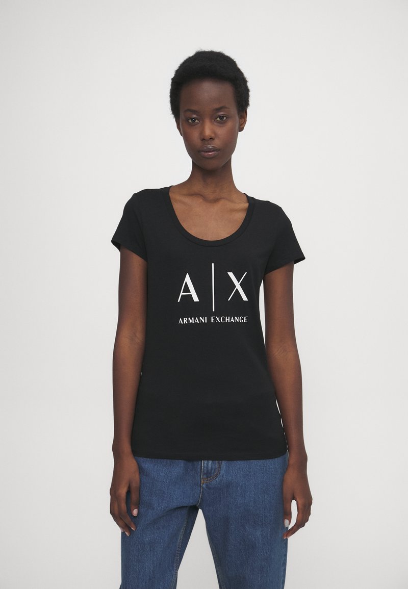 Čierne tričko s krátkym rukávom a okrúhlym výstrihom. Obsahuje biele logo "A|X ARMANI EXCHANGE" na prednej strane. Mäkký bavlnený materiál.