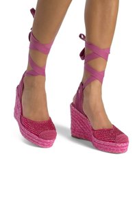 Sandalias de cuña rosas con una base tejida texturizada, acentos de strass brillantes en la punta y cintas de satén en el tobillo entrelazadas.