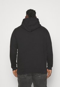 Black hoodie with a spacious hood, long sleeves, and ribbed cuffs. Made of soft cotton fabric, featuring a relaxed fit and minimal design.