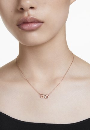 Collier infini en or rose avec des pierres d'accent claires, doté d'une chaîne délicate et d'une finition lisse et polie.