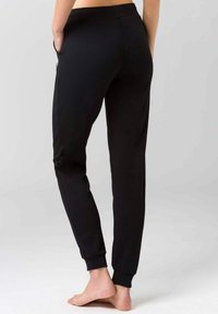Sorte bomulds joggingbukser med tapered fit, elastisk talje, sidelommer og ribbede ankler. Glat tekstur, minimalistisk design.