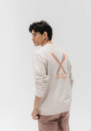 Sudadera de un beige claro con mangas largas, que presenta un gráfico de líneas cruzadas en naranja y gris en la parte posterior, y el texto "el Pulpo" debajo.