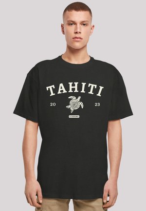 Black cotton t-shirt featuring "TAHITI" text and a turtle graphic in white. Short sleeves and relaxed fit. Simple design with no additional patterns.