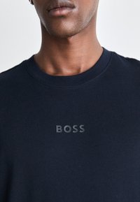 Tengerészkék pamutsweatshirt ribbed crew nyakkal és a mellkasán egy kiemelt, diszkrét "BOSS" logóval. Puha tapintás, testreszabott illeszkedés.