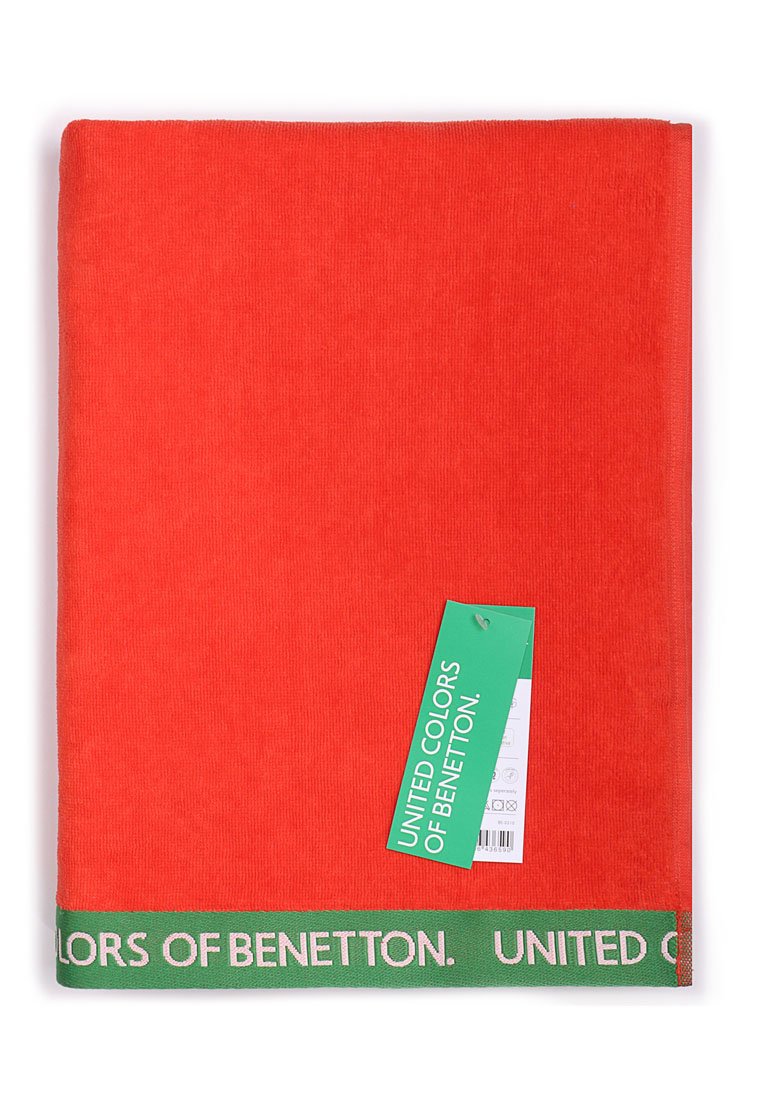 Serviette orange vif en tissu éponge doux, avec une bande verte portant l'inscription "UNITED COLORS OF BENETTON" en blanc.