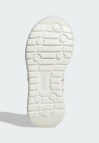 Biely gumový podrážka s okrúhlym vzorom, s vodorovnými drážkami a kruhovými akcentmi, značkovaná s "adidas" po stranách.