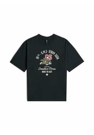T-shirt noir à manches courtes avec un motif d'abeille, des lettres rouges "GS" et un texte indiquant "98th A.M.S Denim Soon Creative Force Built to Last."