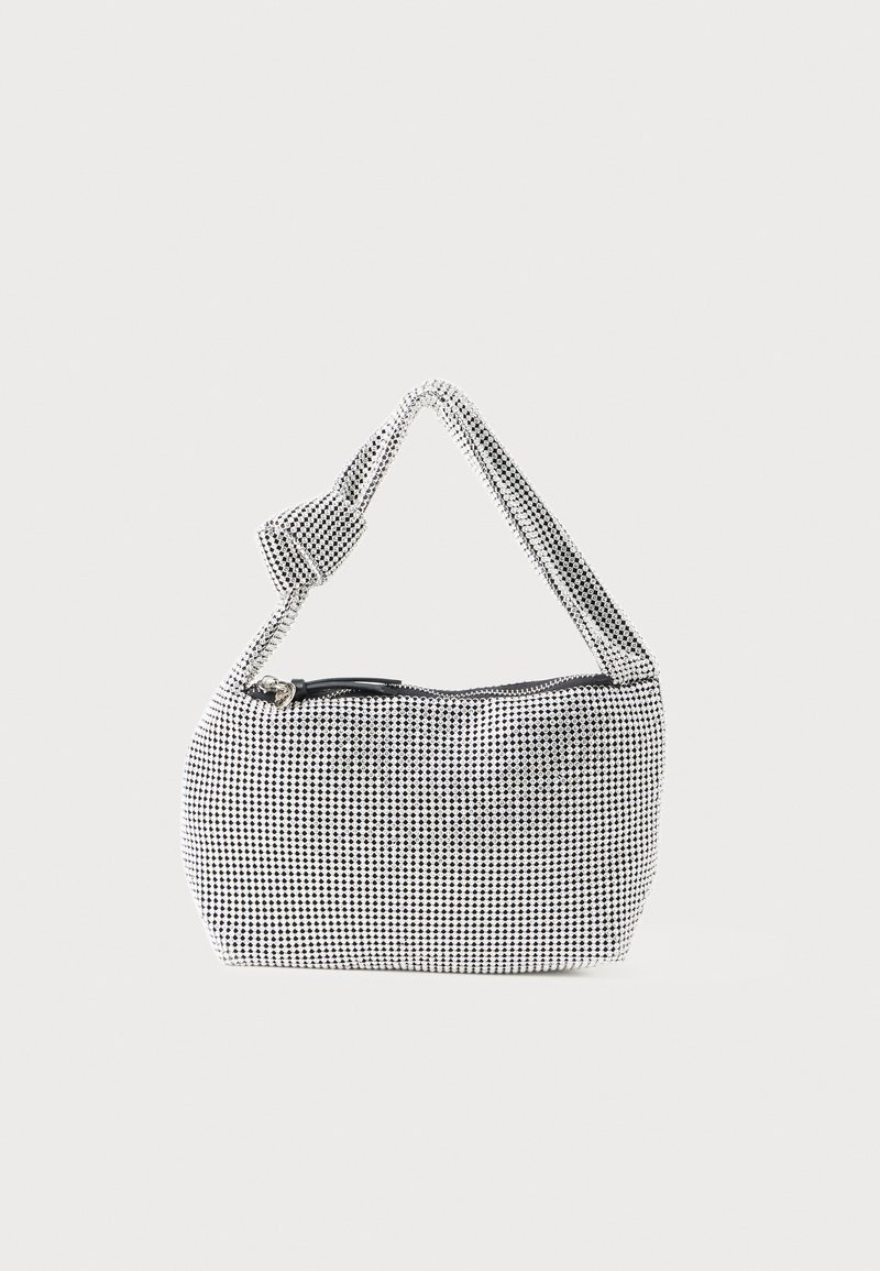 Piccola borsa bianca con pois neri, manico morbido annodato e chiusura con zip superiore.