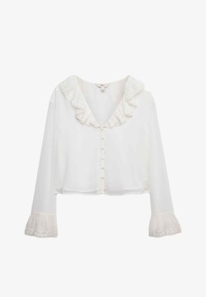 Blouse blanche cropped avec un col en dentelle, des manches longues avec des accents en dentelle aux poignets, et fermeture à boutons sur le devant.