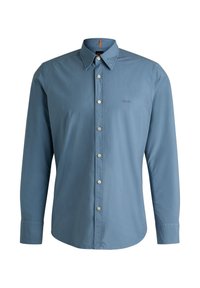 Camisa de manga larga, color azul claro, hecha de algodón, con cierre de botones en el frente, cuello puntiagudo y un logotipo sutil en el pecho. Tejido texturizado.