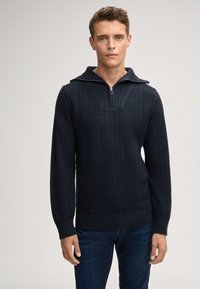 Navy-blau gestrickter Pullover mit Reißverschlusskragen, strukturiertem Muster und gerippten Bündchen und Saum. Slim Fit, mit einem v-förmigen Detail auf der Brust.