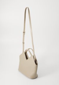 Beige leather handbag with a structured design, featuring a V-shaped top, adjustable strap, and dual handles for versatility.