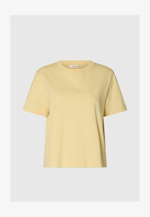 Kortermet, lys gul bomulls-t-skjorte med rund hals og rett kant på ensfarget grå bakgrunn.