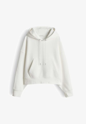 White cropped hoodie made of soft fabric, featuring a front pocket, drawstring hood, and ribbed cuffs. Simple and unadorned design.