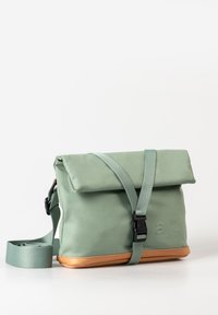 Borsa a rotolo verde con base marrone, cintura regolabile e fibbia in plastica. Realizzata in materiale liscio con dettaglio del logo in rilievo sul lato.