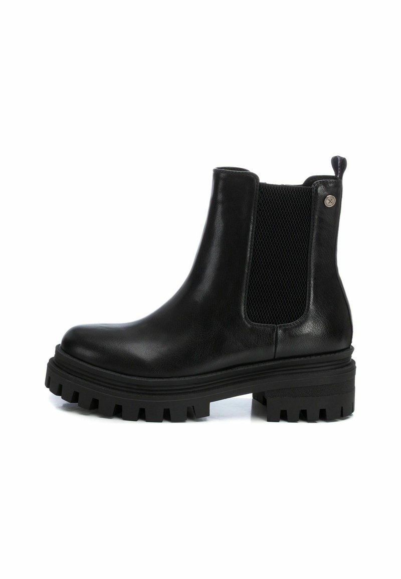 Bottines Chelsea en cuir noir avec des panneaux élastiqués sur les côtés, semelle en caoutchouc texturée et un léger talon. Design de semelle remarquable pour une bonne adhérence.