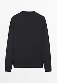 Pull noir à manches longues en tissu doux, avec un design simple comprenant un col rond et des poignets côtelés. Look épuré et minimaliste.