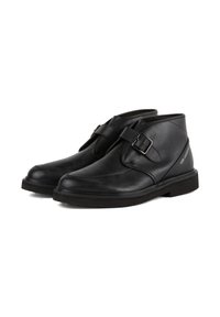 Black leather ankle boots with a buckle strap, rounded toe, and flat rubber sole. Minimalistic design, smooth texture.
