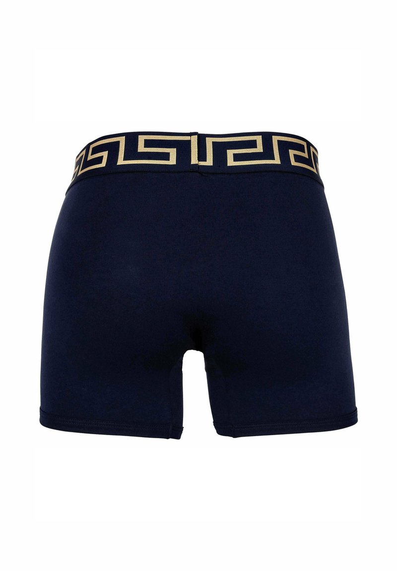 Navy blue boxer shorts featuring a gold Greek key pattern on the waistband, made from a smooth, stretchy material with a fitted design.