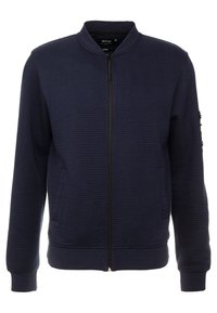 Námornícka bomber bunda na zips s rebrovým textúrou, stojatým golierom, dvoma prednými vreckami a zipsovým vreckom na rukáve. Mäkký materiál.