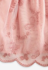 Tissu en tulle rose orné de papillons et de fleurs brodés. Ourlet festonné avec couture décorative. Tissu léger avec des détails de design complexes.